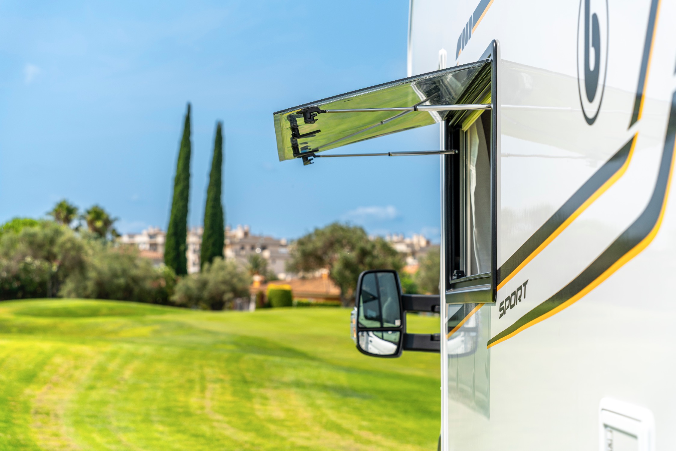 Autocaravana Ford Benimar S344 UP aparcada en una pradera junto a olivos